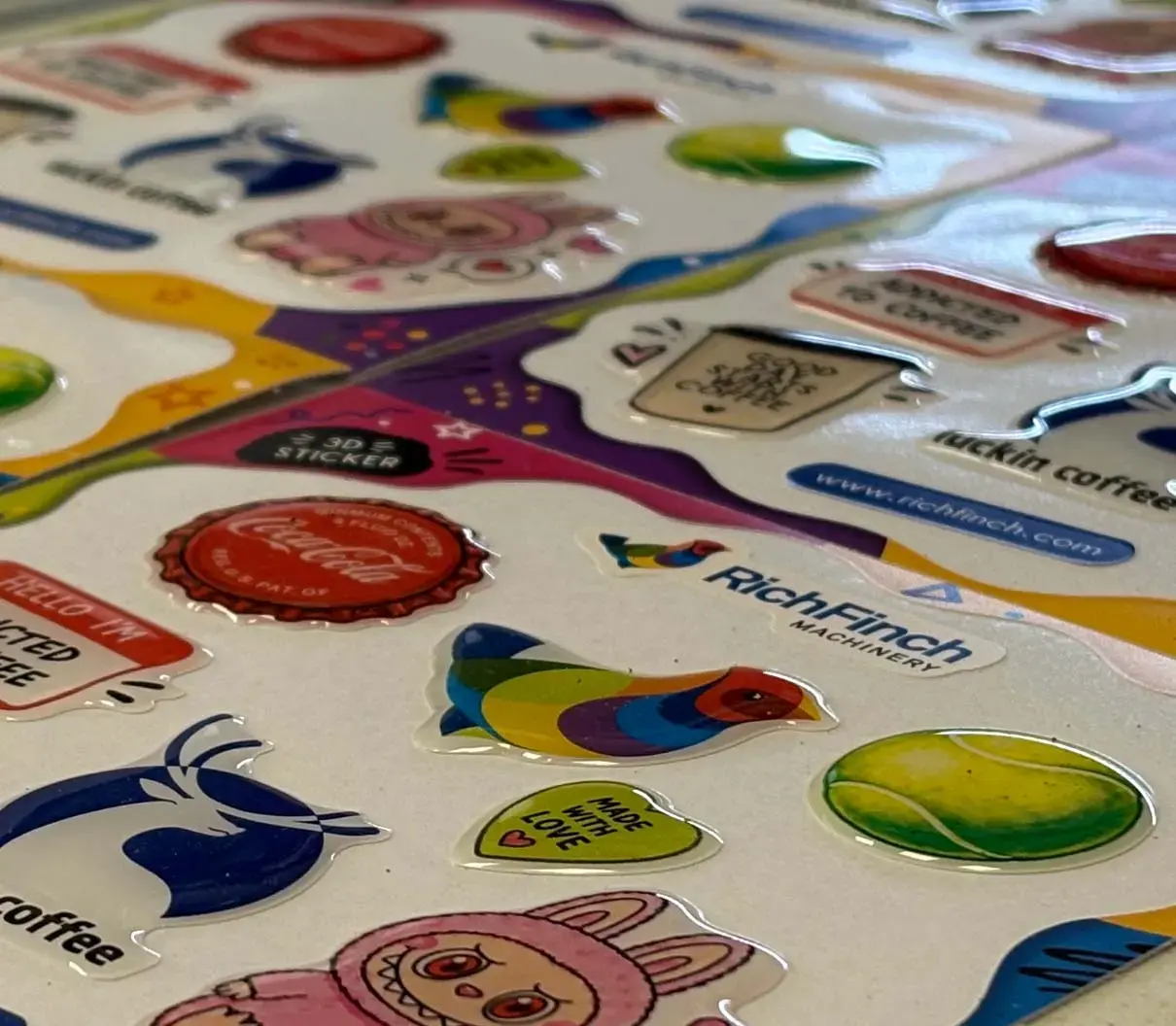 Sheet of glossy domed stickers photographed at a low angle, the domes catching the light