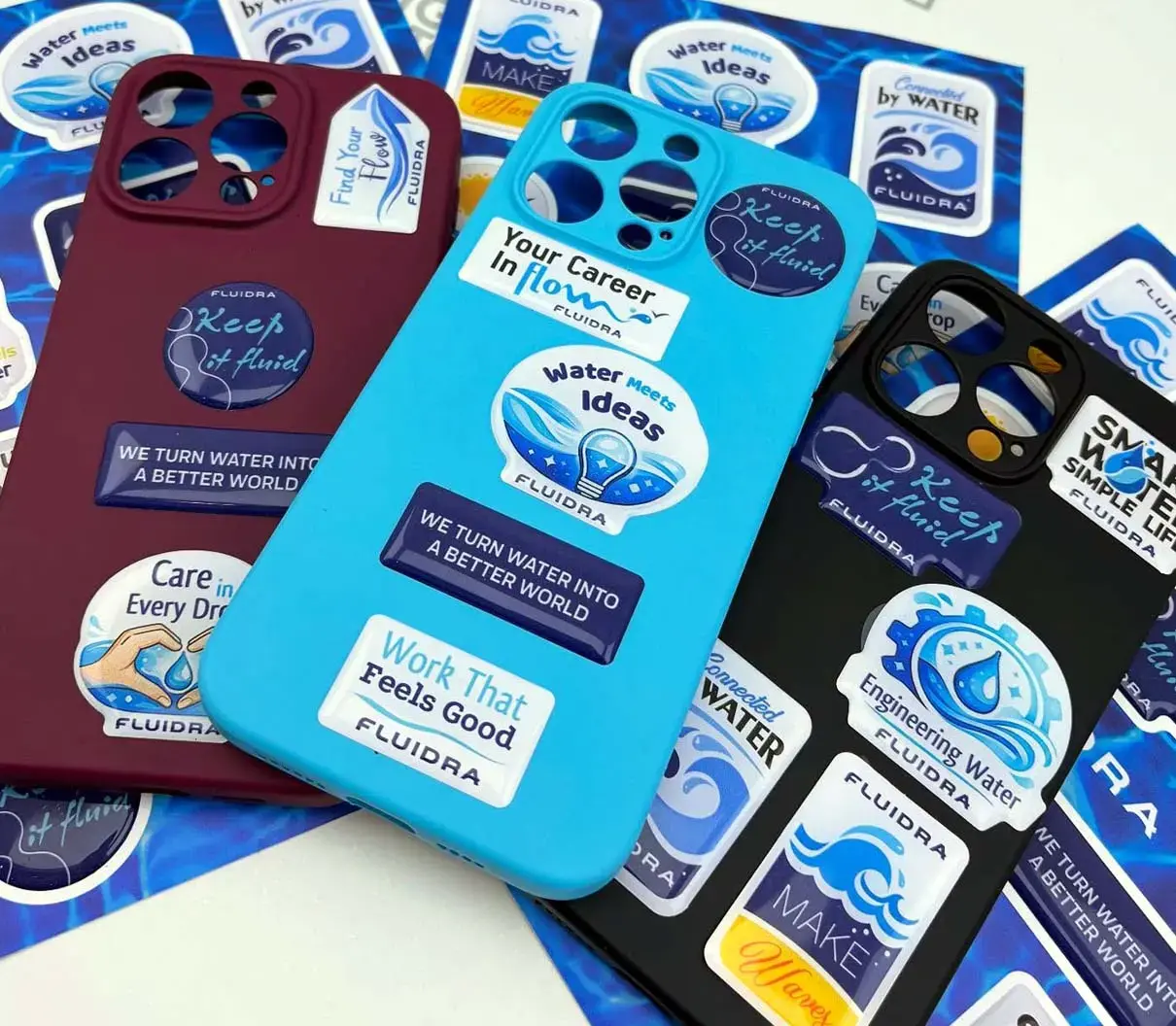 Phone cases with company-branded domed stickers, laid on sheets of the same design